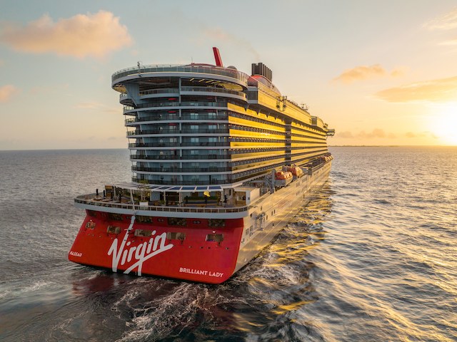 The Virgin Voyages ship Brilliant Lady sailing at sunset